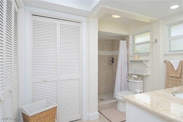 bathroom with tile patterned flooring, vanity, toilet, and walk in shower