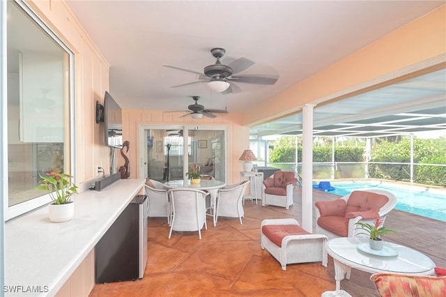 sunroom featuring ceiling fan and a pool