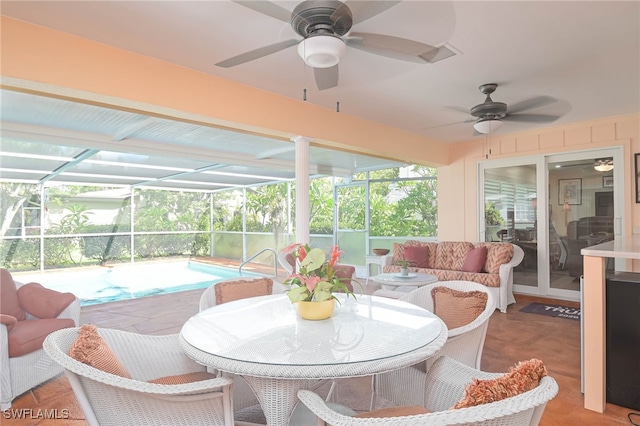 sunroom / solarium featuring plenty of natural light, ceiling fan, and a swimming pool