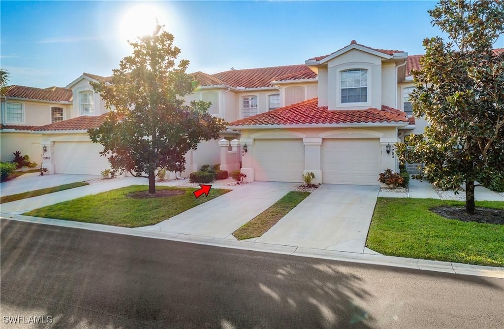 mediterranean / spanish house with a garage and a front lawn