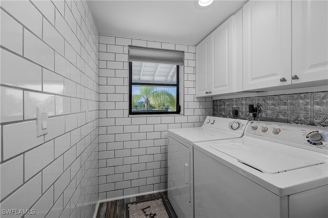 washroom featuring hardwood / wood-style floors, washer and dryer, and cabinets