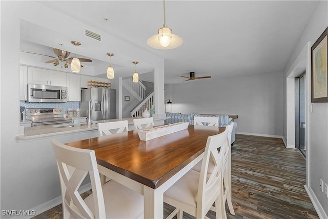 dining room featuring ceiling fan and dark wood-type flooring