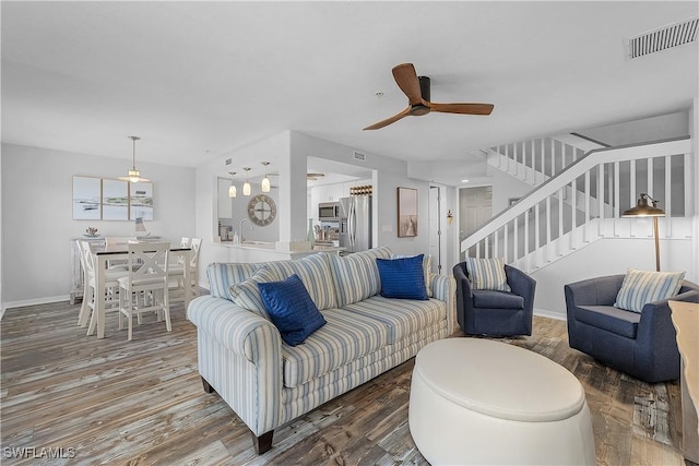 living room with ceiling fan, hardwood / wood-style floors, and sink