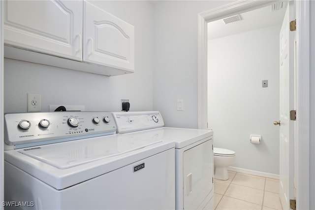 washroom featuring cabinets, light tile patterned floors, and washer and clothes dryer