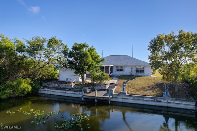 rear view of house featuring a yard and a water view