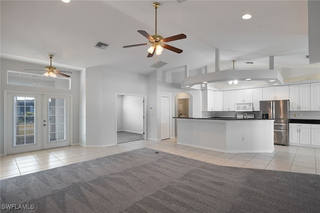 kitchen featuring white cabinets, french doors, light tile patterned flooring, and stainless steel fridge