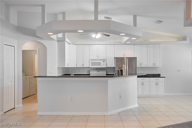 kitchen with white cabinets, white appliances, light tile patterned flooring, washer and clothes dryer, and high vaulted ceiling