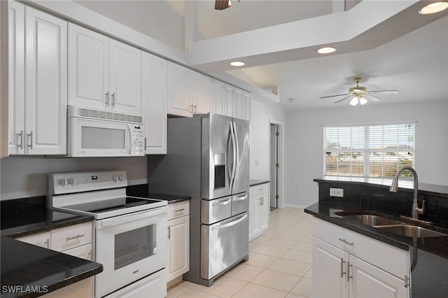 kitchen with sink, white cabinets, white appliances, light tile patterned flooring, and ceiling fan