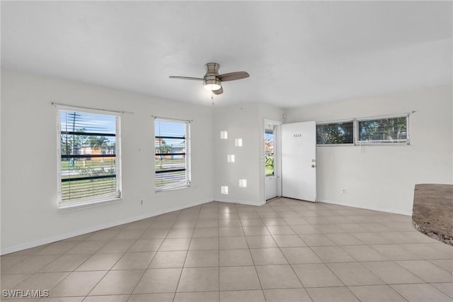 tiled spare room featuring ceiling fan