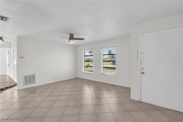 tiled empty room featuring ceiling fan