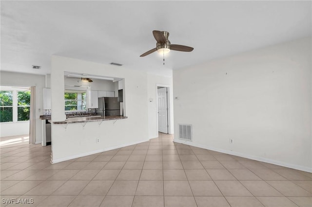 unfurnished living room featuring ceiling fan and light tile patterned floors