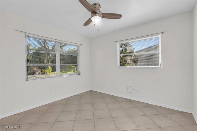 tiled empty room with ceiling fan and a wealth of natural light