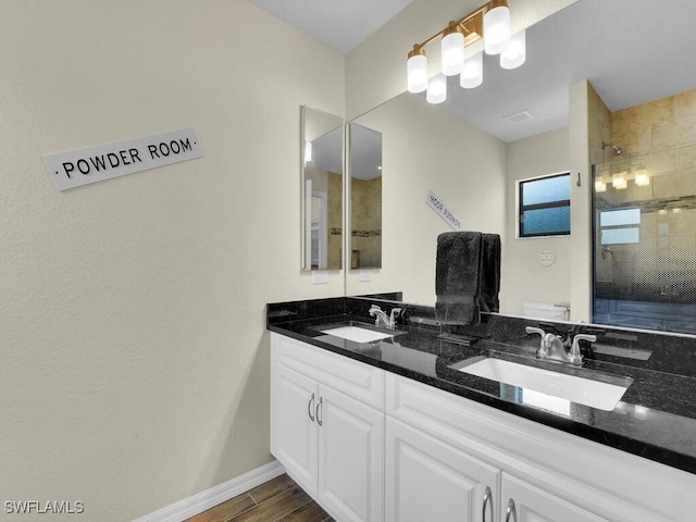 bathroom with a tile shower, vanity, and toilet