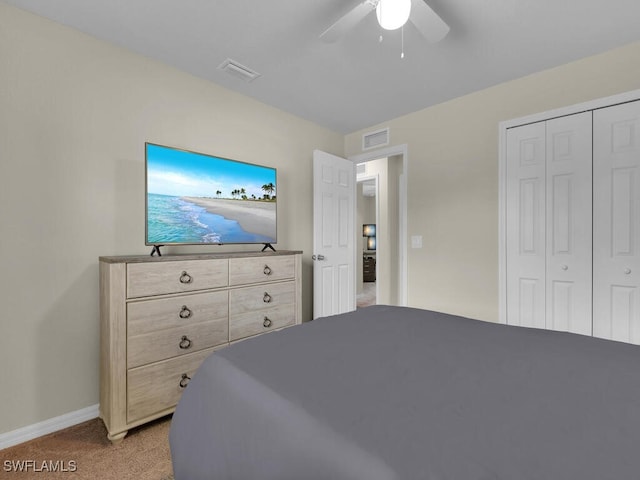 bedroom with ceiling fan, light carpet, and a closet