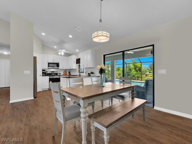 dining space featuring ceiling fan, dark hardwood / wood-style flooring, and vaulted ceiling