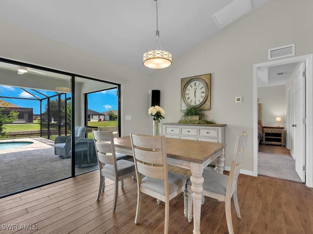 dining area featuring light hardwood / wood-style floors and lofted ceiling