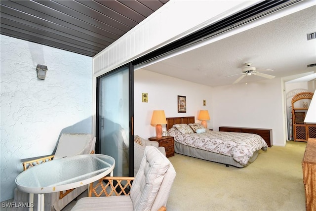 bedroom with ceiling fan, light carpet, and a textured ceiling