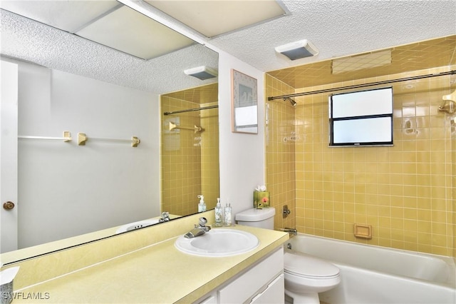 full bathroom with toilet, vanity, a textured ceiling, and tiled shower / bath