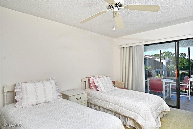 bedroom with access to exterior, ceiling fan, carpet floors, and a textured ceiling