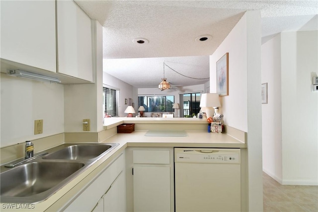 kitchen with a textured ceiling, white dishwasher, white cabinetry, and sink