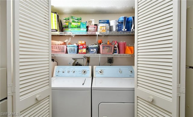 clothes washing area featuring a textured ceiling and washing machine and clothes dryer