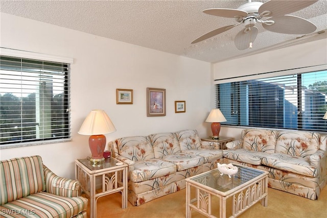 living room featuring ceiling fan, light colored carpet, and a textured ceiling