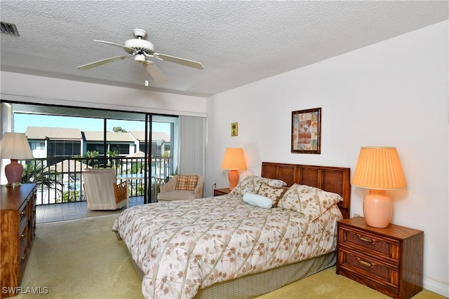 carpeted bedroom featuring ceiling fan, access to exterior, and a textured ceiling