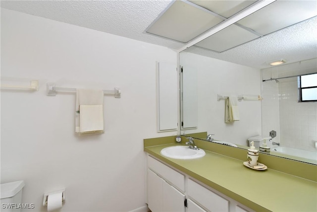 full bathroom with vanity, tiled shower / bath combo, a textured ceiling, and toilet