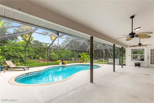 view of pool featuring a patio, glass enclosure, and ceiling fan