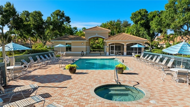 view of swimming pool featuring a hot tub and a patio area