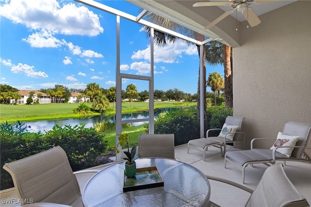 sunroom / solarium featuring a water view and ceiling fan