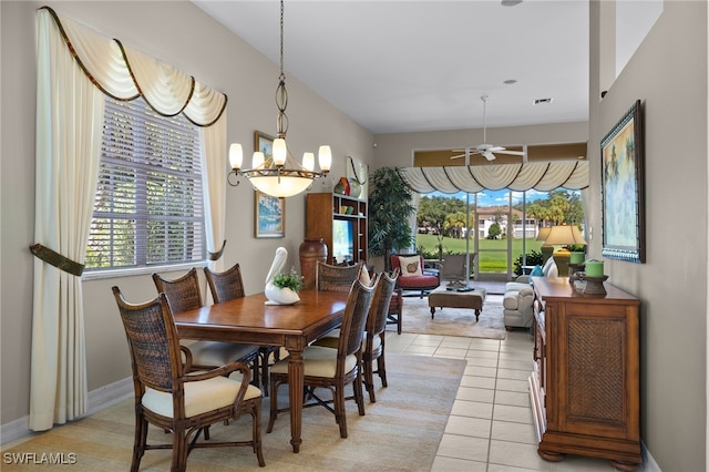 dining space featuring light tile patterned floors and ceiling fan with notable chandelier