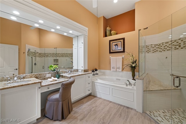 bathroom with vanity and shower with separate bathtub