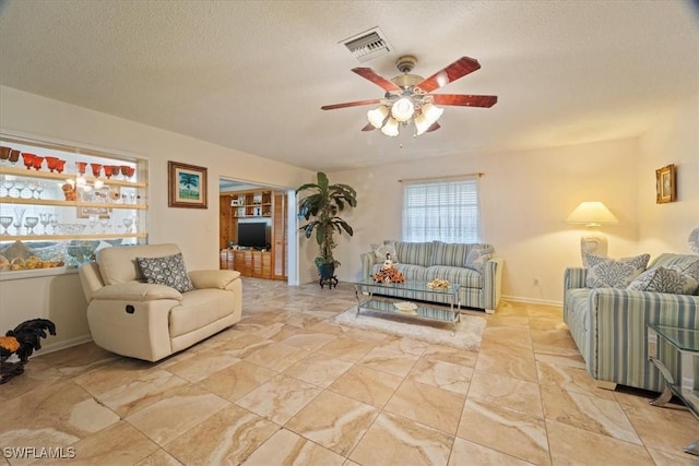 living room featuring a textured ceiling and ceiling fan