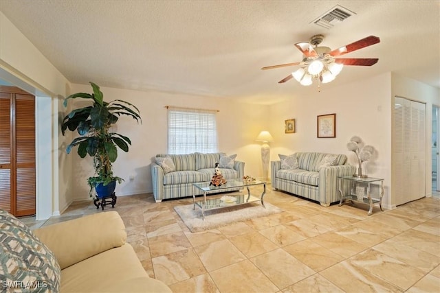 living room with a textured ceiling and ceiling fan