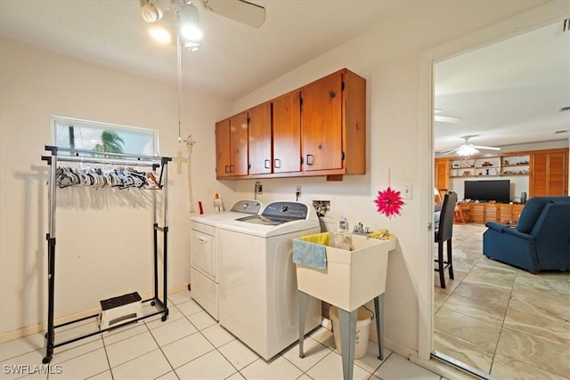 clothes washing area with ceiling fan, light tile patterned flooring, cabinets, and independent washer and dryer