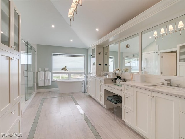 full bathroom featuring lofted ceiling, a shower stall, recessed lighting, a freestanding tub, and vanity