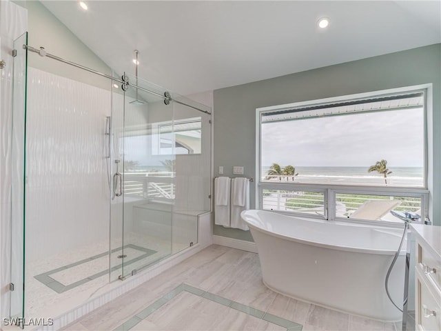 full bathroom featuring a freestanding tub, a shower stall, lofted ceiling, and recessed lighting