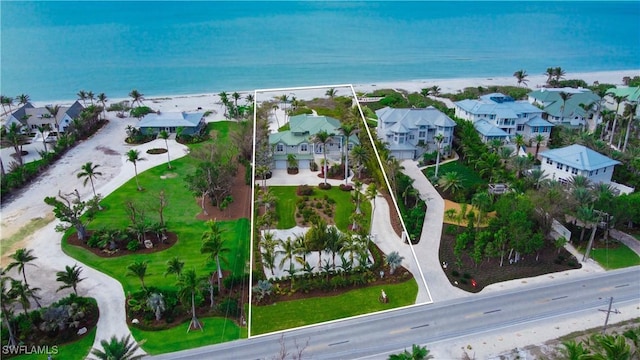 drone / aerial view featuring a residential view, a beach view, and a water view