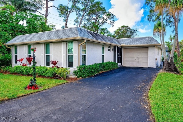 single story home featuring a garage and a front lawn