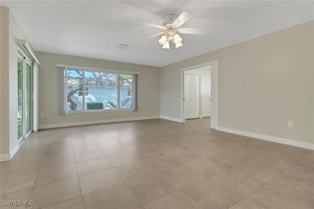 tiled spare room with ceiling fan