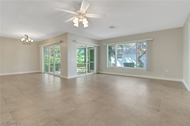 unfurnished room featuring ceiling fan with notable chandelier and light tile patterned floors