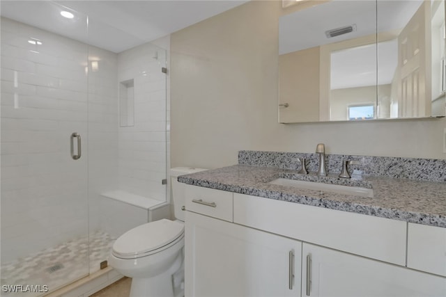 bathroom with vanity, walk in shower, and toilet