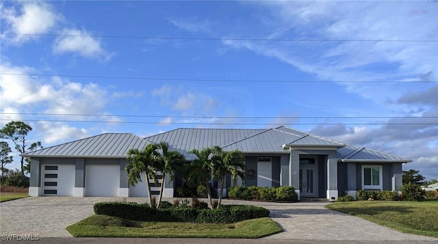 view of front of home with a garage and a front lawn