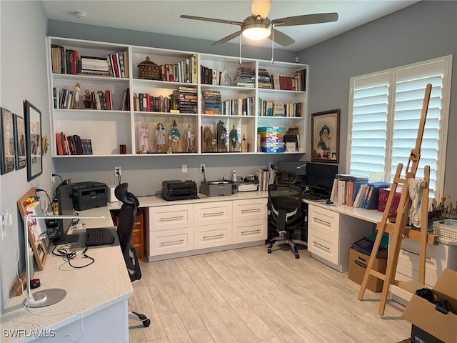 office area with ceiling fan, built in desk, and light hardwood / wood-style flooring