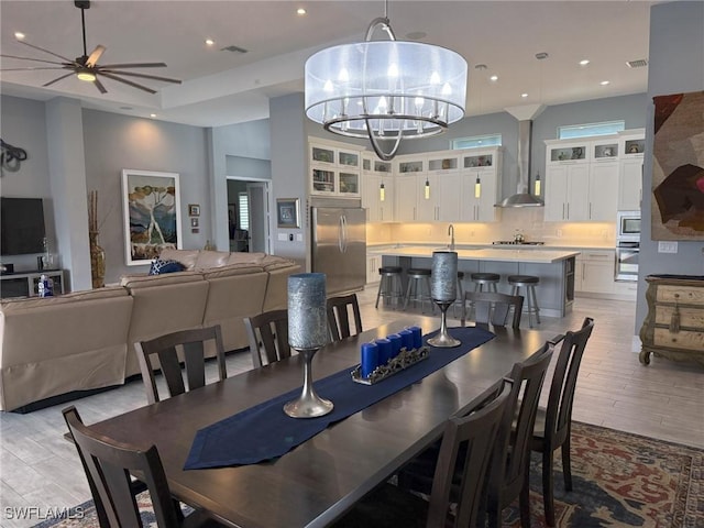 dining space featuring ceiling fan with notable chandelier