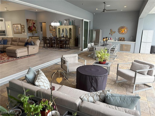 living room featuring ceiling fan with notable chandelier