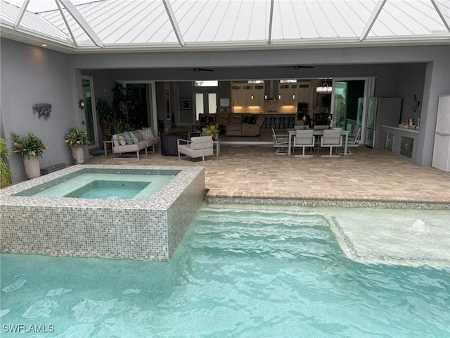 view of swimming pool featuring an in ground hot tub, an outdoor living space, a patio, and ceiling fan