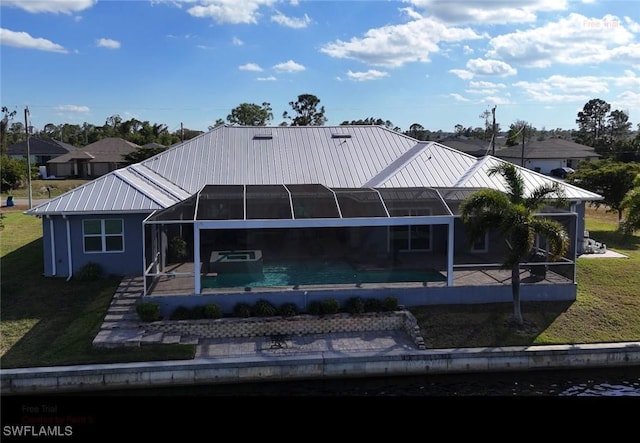 rear view of house with a lanai and a yard