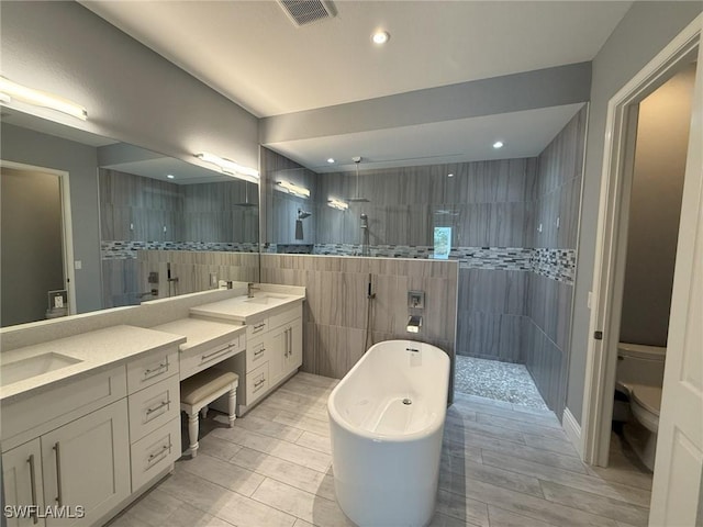 full bathroom with vanity, separate shower and tub, toilet, and tile walls